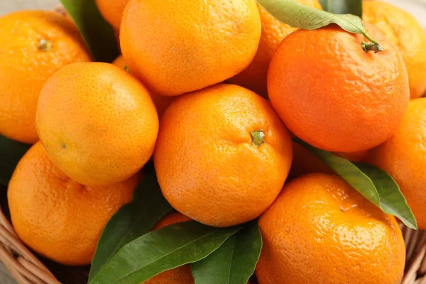 Taze mandalina ve yeşil yapraklar masada, yakın plan.