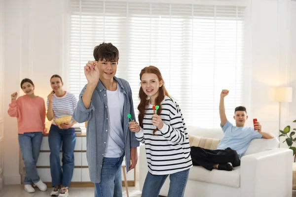 Evde dart oynayan bir grup genç, seçici bir odak