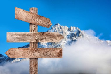 Dağlara karşı farklı yönlere bakan okları olan tahta tabela direği.