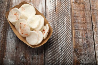 Lezzetli pirinç cipsleri paket kutusunda ahşap masa üzerinde, üst manzara. Metin için boşluk