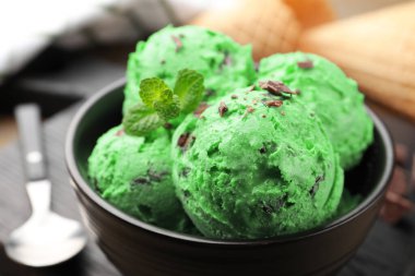 Çikolata parçalı lezzetli dondurma ve waffle külahları ahşap masada, yakın plan.