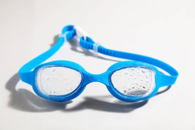 Açık arkaplanda mavi yüzme gözlükleri, yakın plan.