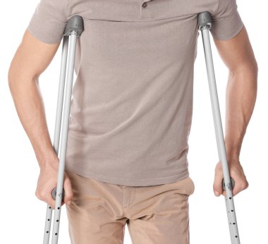 Beyaz arka planda koltuk değnekli adam, yakın plan