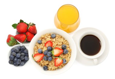 Healthy breakfast. Oatmeal with berries, coffee and orange juice isolated on white, top view