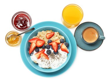 Sağlıklı kahvaltı. Böğürtlenli yulaf ezmesi, reçel, kahve ve portakal suyu beyaza izole edilmiş.