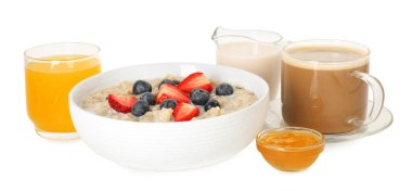 Sağlıklı kahvaltı. Böğürtlenli yulaf ezmesi, reçel, kahve, süt ve portakal suyu beyaz üzerine izole edilmiş