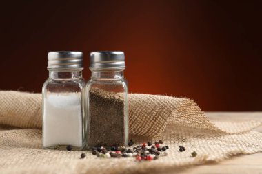 Tuz ve biber karıştırıcılar ahşap masa üzerinde koyu arkaplan, metin için boşluk