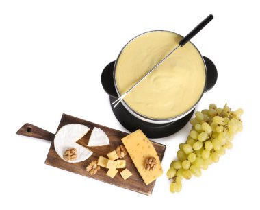 Lezzetli eritilmiş peynirli fondü, parçalar, üzümler ve cevizler beyaza izole edilmiş, üst manzara