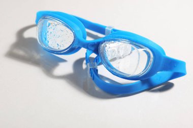 Açık arkaplanda mavi yüzme gözlükleri, yakın plan.
