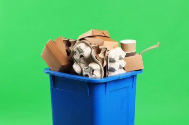 Çöpler yeşil arka planda çöp kutusunda, yakın plan. Atık sıralama