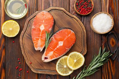 Baharatlı, limonlu ve yağlı somon fileto parçaları ahşap masada, düz yatıyordu.