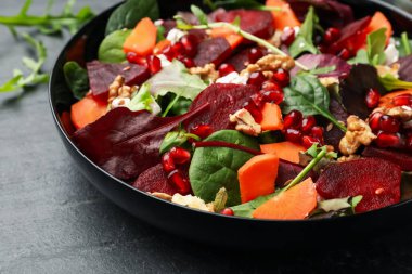 Pancar, ıspanak, roka, peynir, ceviz, havuç ve nar tohumlu nefis salata, yakın plan.