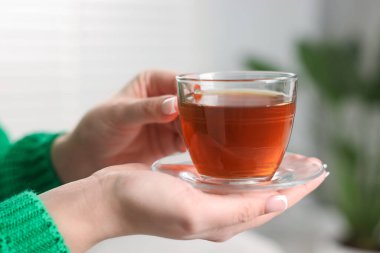 Bir fincan çay tutan kadın, yakın plan.