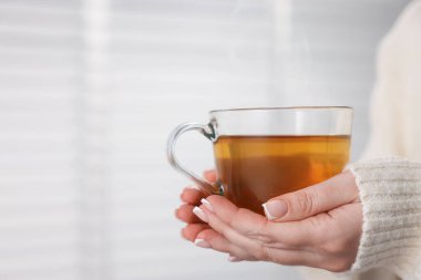 Bir fincan çay tutan kadın, yakın plan. Metin için boşluk