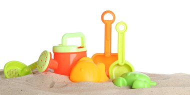 Çocuklar için plaj oyuncakları ve beyaz pankartta izole edilmiş kum. Plastik sulama kutusu, kürek, kalıp ve süzgeç.