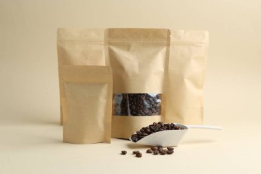 Bej arkaplanda kahve çekirdekleri olan stand-up torbaları.