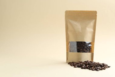 Bej arka planda kahve çekirdekli stand-up kesesi, metin için boşluk