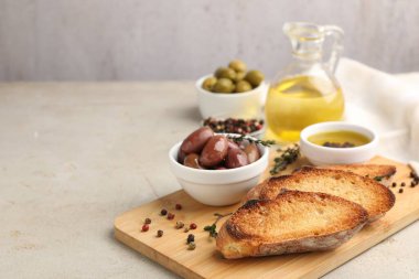 Ekmek dilimleri, yağ, baharatlar ve zeytinler ışık masasında, yakın plan. Metin için boşluk