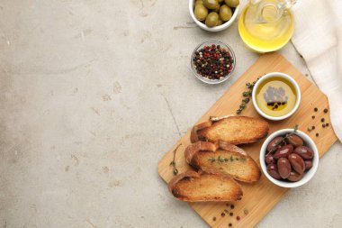 Baget, yağ, baharat ve zeytin dilimleri açık gri masada, düz yerde. Metin için boşluk