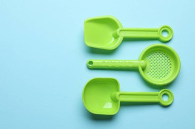 Açık mavi arka planda parlak çocukların plaj oyuncakları, düz yatış. Metin için boşluk