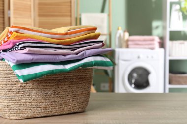 İçerideki ahşap masada giysileri olan çamaşır sepeti, yakın çekim. Metin için boşluk