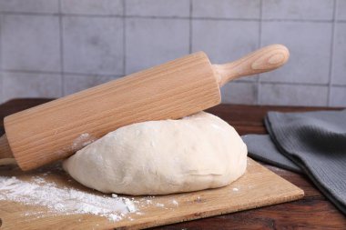 Hamur, merdane ve un ahşap masada, yakın plan.