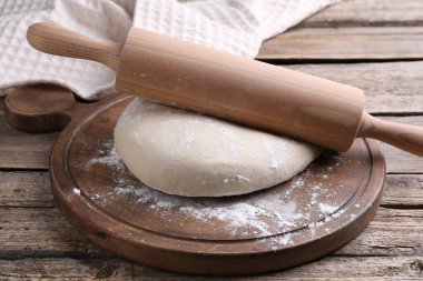 Hamur unu ve oklavayla ahşap masaya yakın çekim.