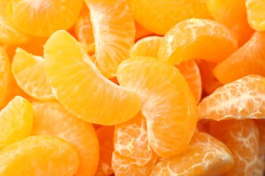 Arka plan olarak birçok olgun soyulmuş mandalina, üst görünüm