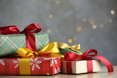 Noel hediyesi kutuları ahşap masanın üzerinde gri arka planda, flaşlı, yakın plan. Metin için boşluk
