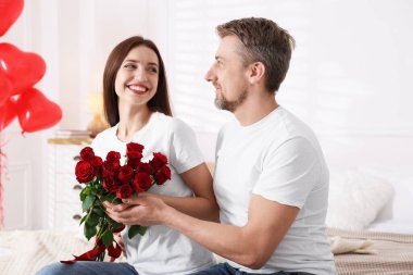 İçeride gül buketi olan mutlu bir çift. Sevgililer Günü kutlaması