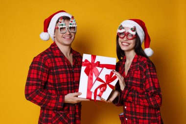 Noel Baba şapkalı ve pijamalı mutlu çift.