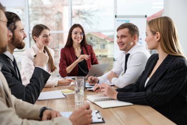 İş adamlarından oluşan bir ekip ofiste birlikte çalışıyor.