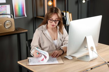 Ofiste ahşap giysiler tasarlayan tasarımcı.