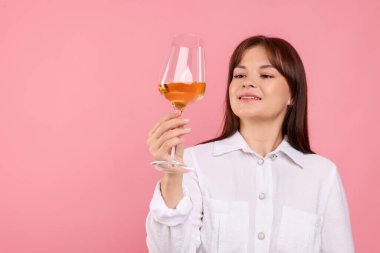 Pembe arka planda beyaz şarap kadehi olan profesyonel şarap garsonu.