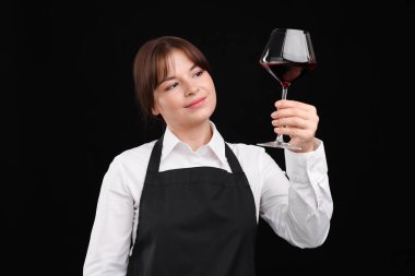 Siyah arka planda kırmızı şarap kadehi olan profesyonel şarap garsonu.