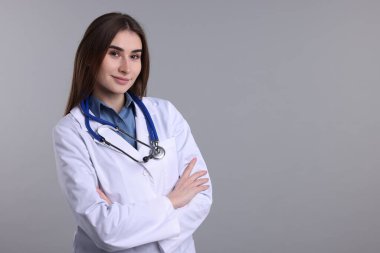 Gri arkaplanda tıbbi asistanın portresi, metin için boşluk