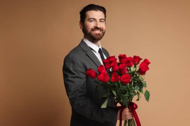 Sevgililer Günü. Bej arka planda gül demeti olan bir adam.
