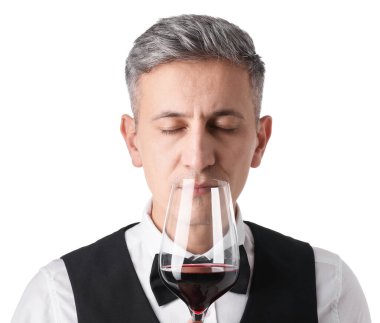 Profesyonel şarap garsonu beyaz arka planda kırmızı şarap tadıyor.