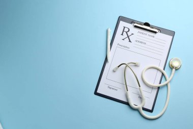 Açık mavi zemin üzerinde boş alanlar ve kalem bulunan tıbbi reçete formu, üst görünüm. Metin için boşluk