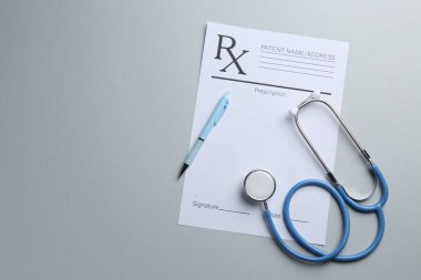 Boş tarlaları, steteskopu ve açık gri arka planı olan bir tıbbi reçete formu. Metin için boşluk