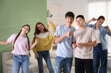 Genç arkadaşlar evde birlikte karaoke yapıyorlar.