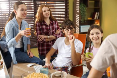 Bilgisayar masasında aperatifleri olan bir grup genç.