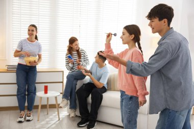 Evde dart oynayan bir grup genç.