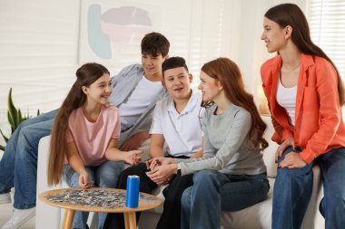 Evde bulmaca çözen bir grup genç.