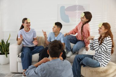 Alnında yapışkan notlar olan bir grup genç arkadaş tahmin et evde kim oynuyor?