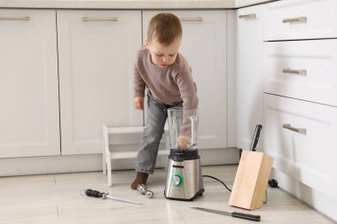 Evde çocuk güvenliği. Küçük çocuk içeride mutfak malzemeleriyle oynuyor.