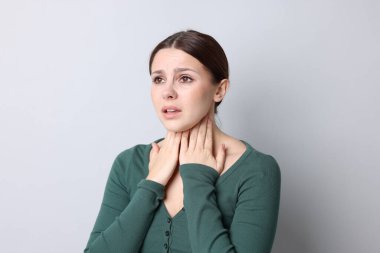 Arka planda boğaz ağrısı çeken bir kadın. Soğuk Semptom