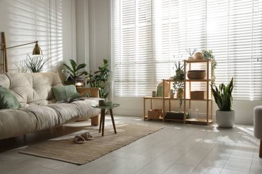 Kanepesi ve çiçekleri olan şık bir oturma odası. İç tasarım