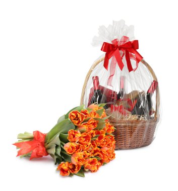 Beyaz arka planda hediye sepeti ve bir buket lale çiçeği.