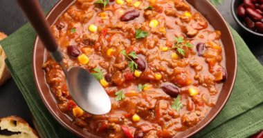 Siyah masada kırmızı biber yiyen bir kadın, yakın plan.